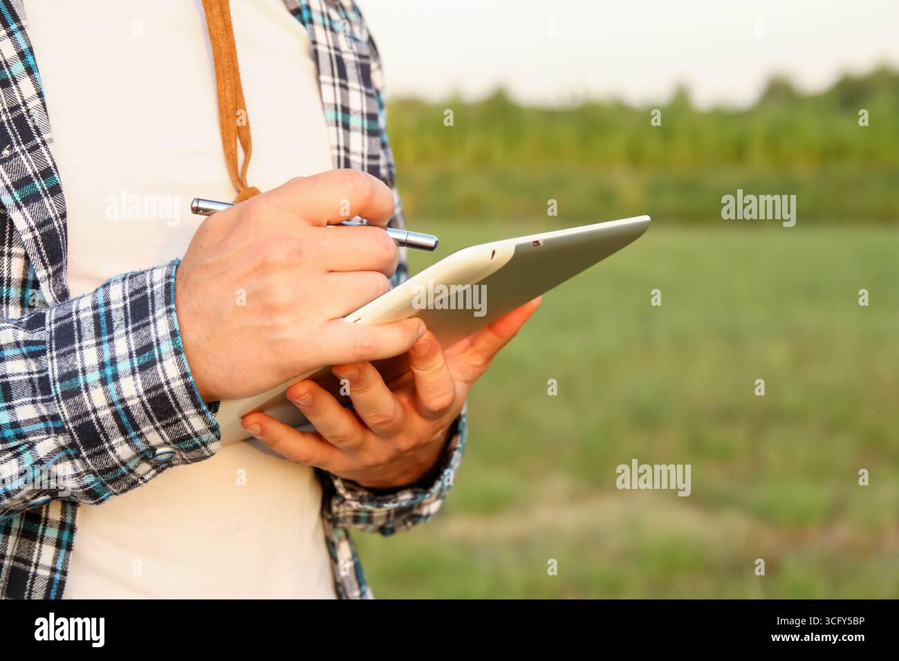 un agricoltore che utilizza un tablet in un campo agricolo. Agricoltore con intelligenza artificiale tablet per l'agricoltura. scienza dei dati della tecnologia agricola intelligente. gestione delle colture agricole di precisione Foto Stock