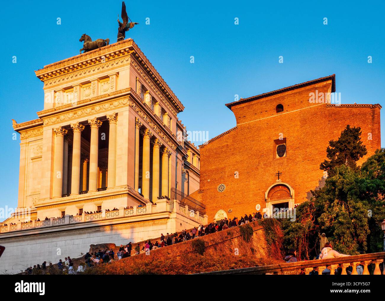 Facciata di Santa Maria in Aracoeli e vista laterale del Vittoriano a Roma, Italia, illuminata dal tramonto. Foto Stock
