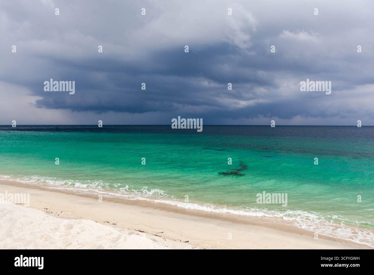 Una tranquilla spiaggia in Thailandia con acque cristalline color smeraldo e spettacolari nuvole di tempesta che si infrangono sul Mare delle Andamane. Koh Adang. Foto Stock