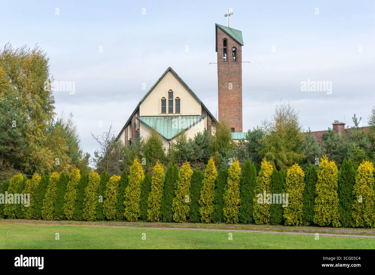 La chiesa di Sant'Anna (Kościół Świętej Anny) fu eretta il settembre 1981. Recinzione, alberi di confine. Lędziny, Polonia. Foto Stock