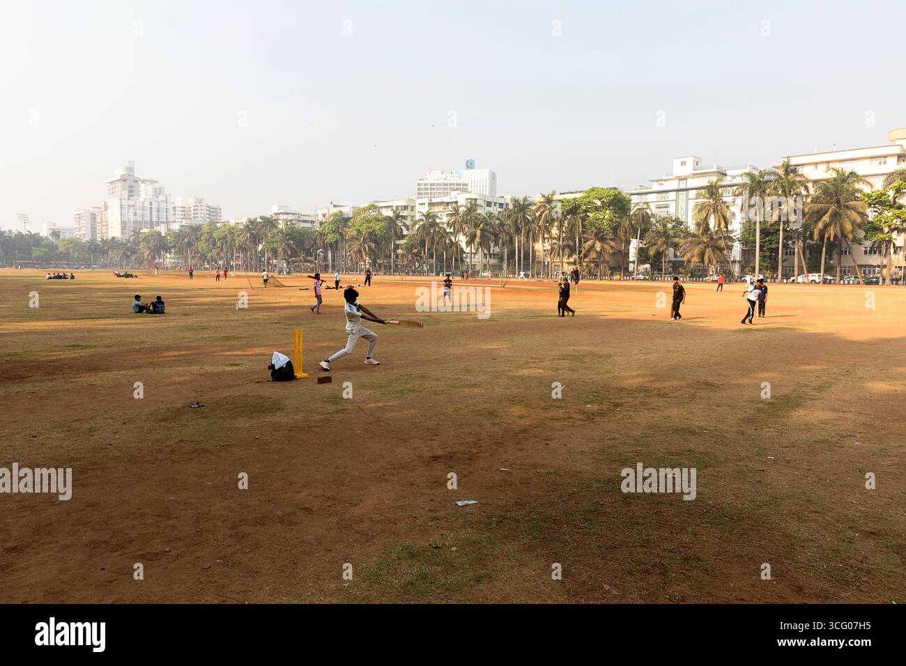 Persone che giocano a cricket in una giornata di sole al mattino nel parco Oval Maidan, Bombay, Mumbai, India Foto Stock