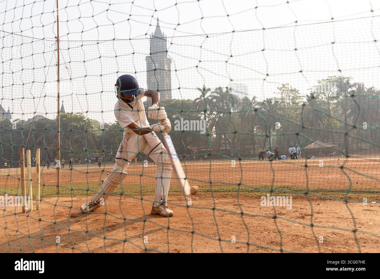 Adolescenti che allenano il cricket in una giornata di sole al mattino nel parco Oval Maidan a Bombay, Mumbai, India Foto Stock