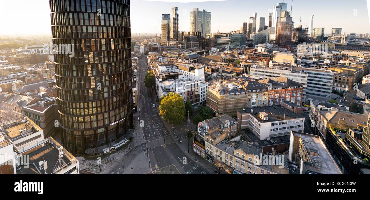 Golden Hour a Shoreditch, Londra. L'art'otel London Hoxton cilindrico si erge alto mentre la città si sveglia. Foto Stock