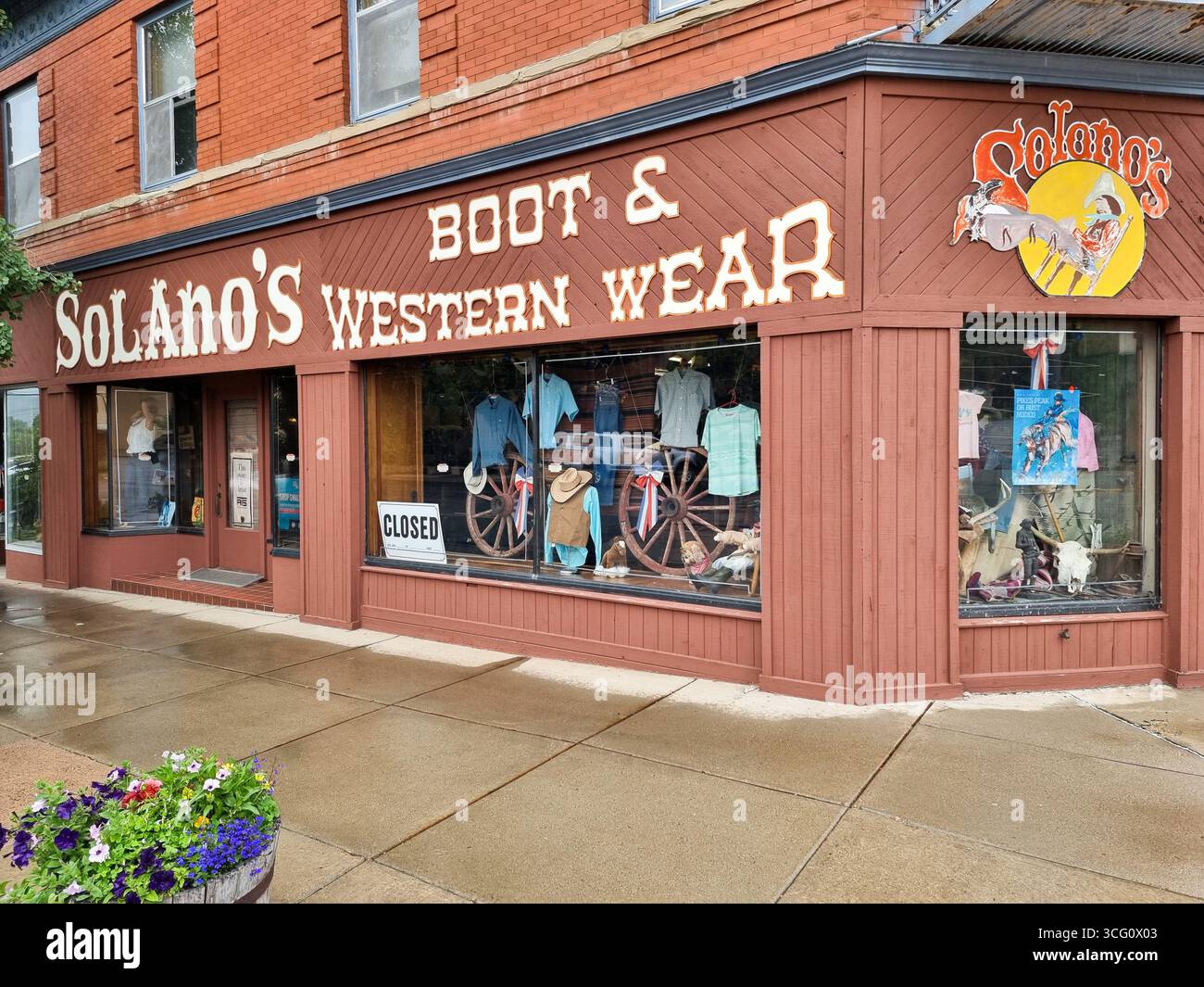 Conserva la facciata del Solano's Boot & Western Wear a Raton, New Mexico, Stati Uniti, con vetrine e cartello "chiuso" - Immagine stock catturata con smartphone