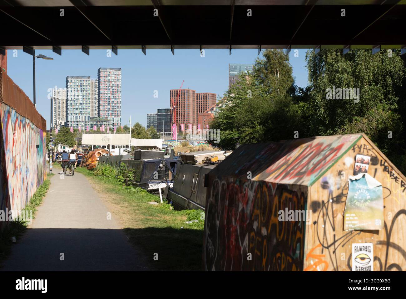 Regent's Canal Towpath a Hackney Wick London, con i nuovi edifici del Queen Elizabeth Olympic Park sullo sfondo. Foto Stock