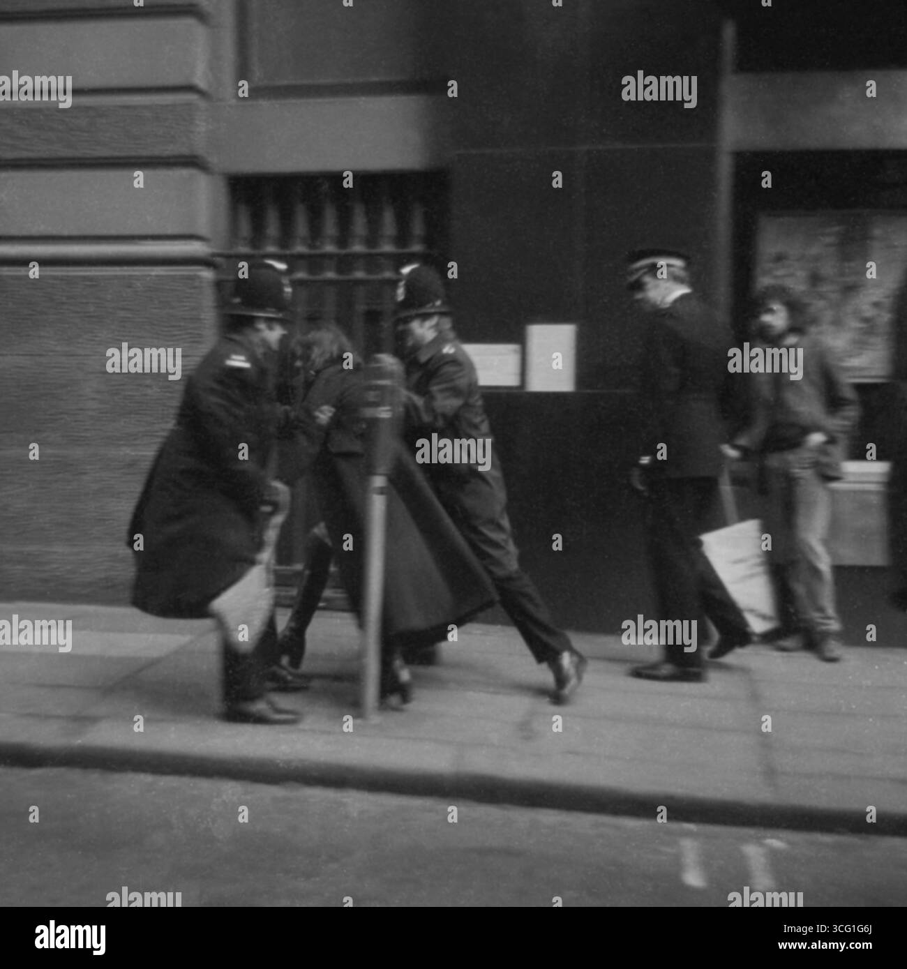 Due agenti di polizia portano via una donna dimostrante durante una contro-manifestazione contro un raduno anti-aborto, Oxford Road, Manchester, all'inizio degli anni '1970. Un altro dimostratore con un cartello, sta guardando. Foto Stock
