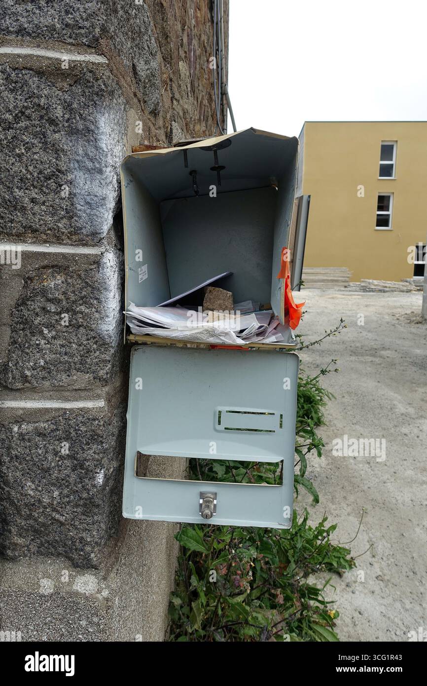 Le lettere sono appesantite con una pietra in una scatola di lettere aperta malconcia, Francia, Bretagna, Yffiniac Foto Stock