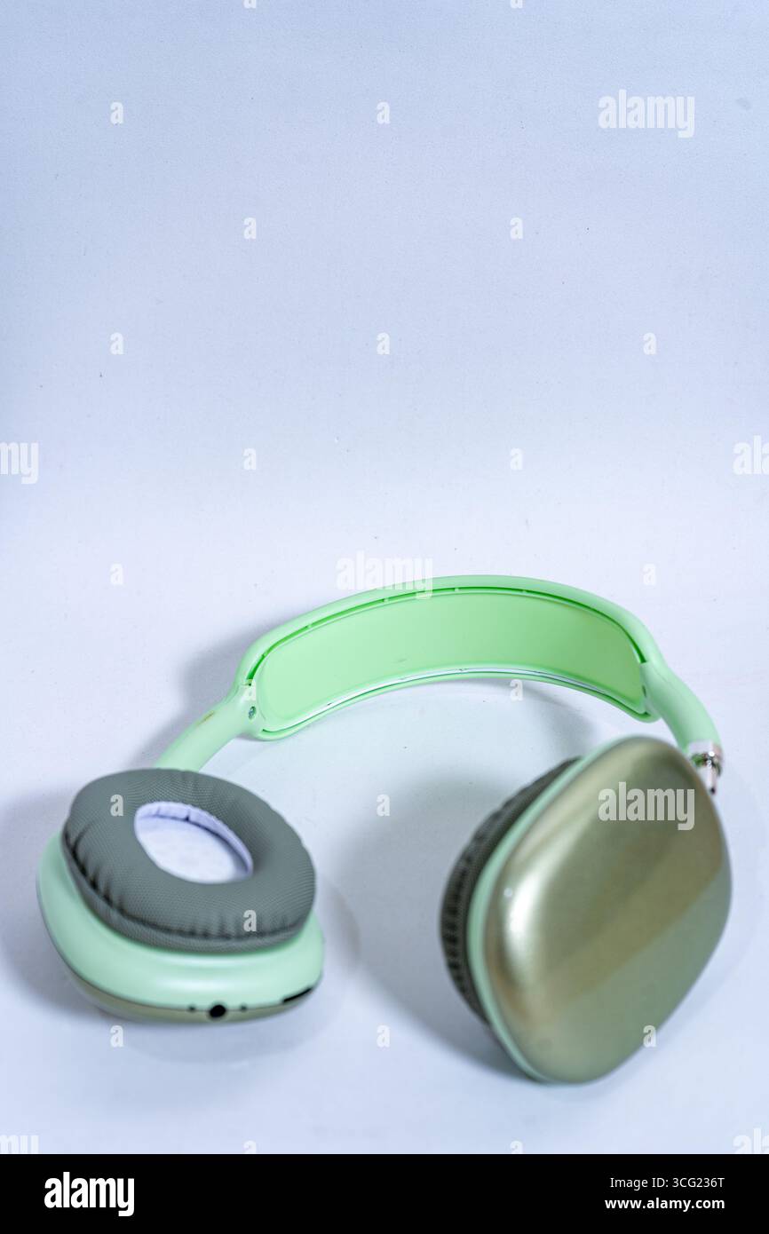 Eleganti cuffie wireless color verde pastello isolate su uno sfondo bianco e pulito, che rappresentano musica, tecnologia e divertimento audio Foto Stock