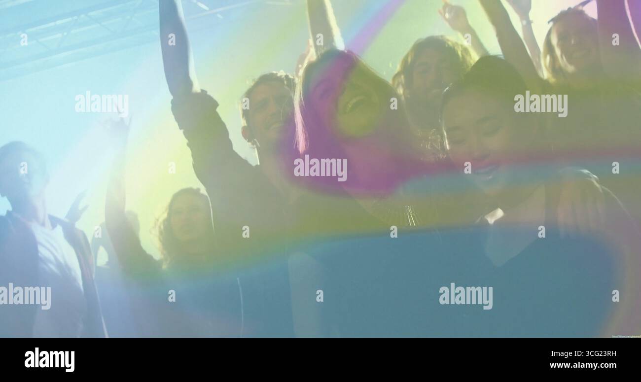 Sei amici che fanno il tifo sotto le luci del club, con un sistema di illuminazione dall'alto e effetti macchina foschia Foto Stock