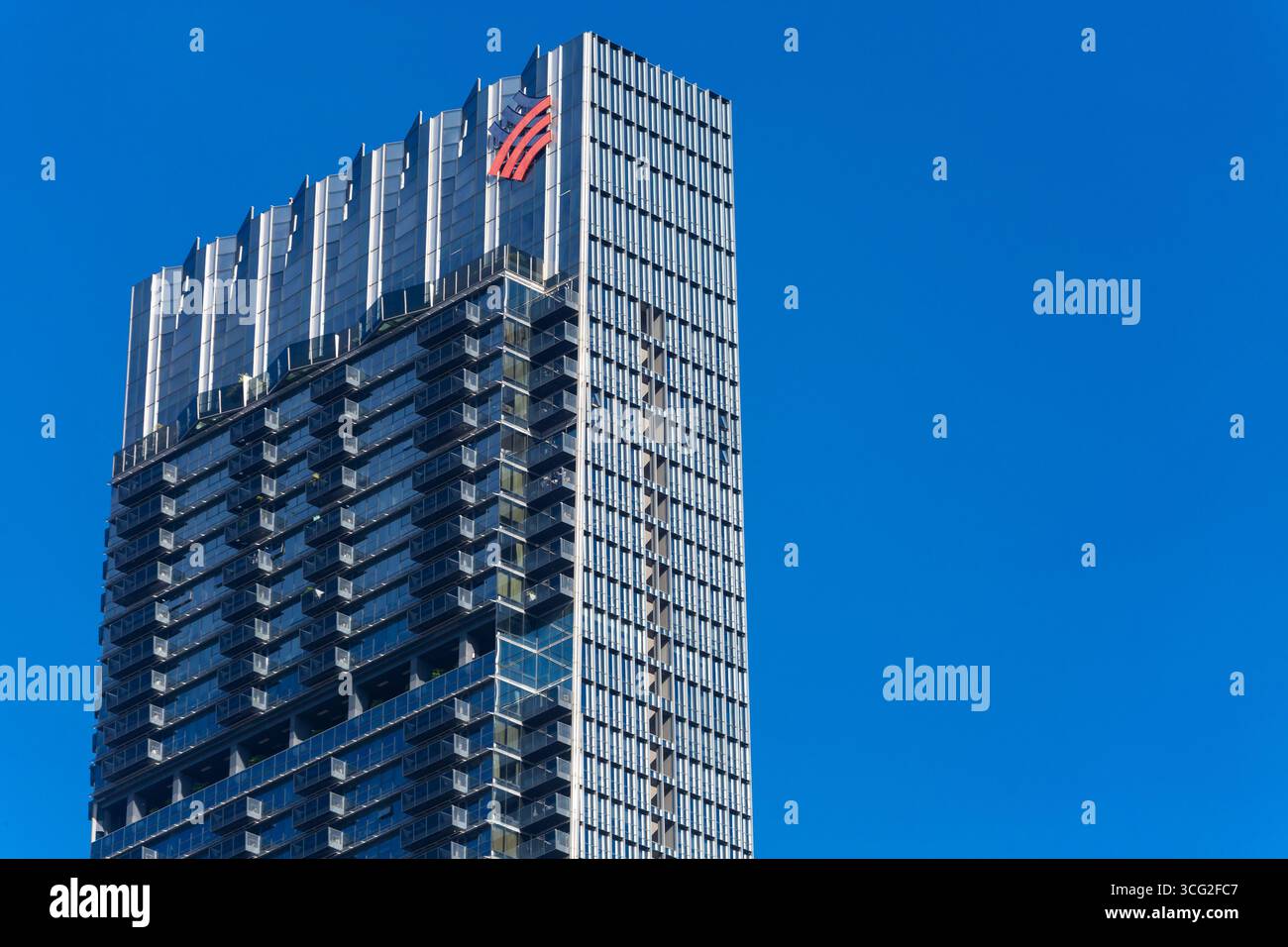 Picco del grattacielo Guoco Tower e logo segnaletica, residenziale nella parte superiore. Il grattacielo più alto di Singapore. Vista ravvicinata. Cielo azzurro. Foto Stock