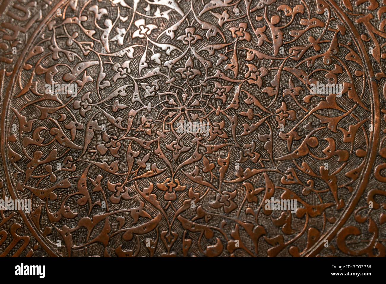 Superficie decorativa in metallo con precisi motivi floreali e circolari realizzati a mano, che mostrano l'arte e l'artigianato tradizionali, sfondo fotografico Foto Stock