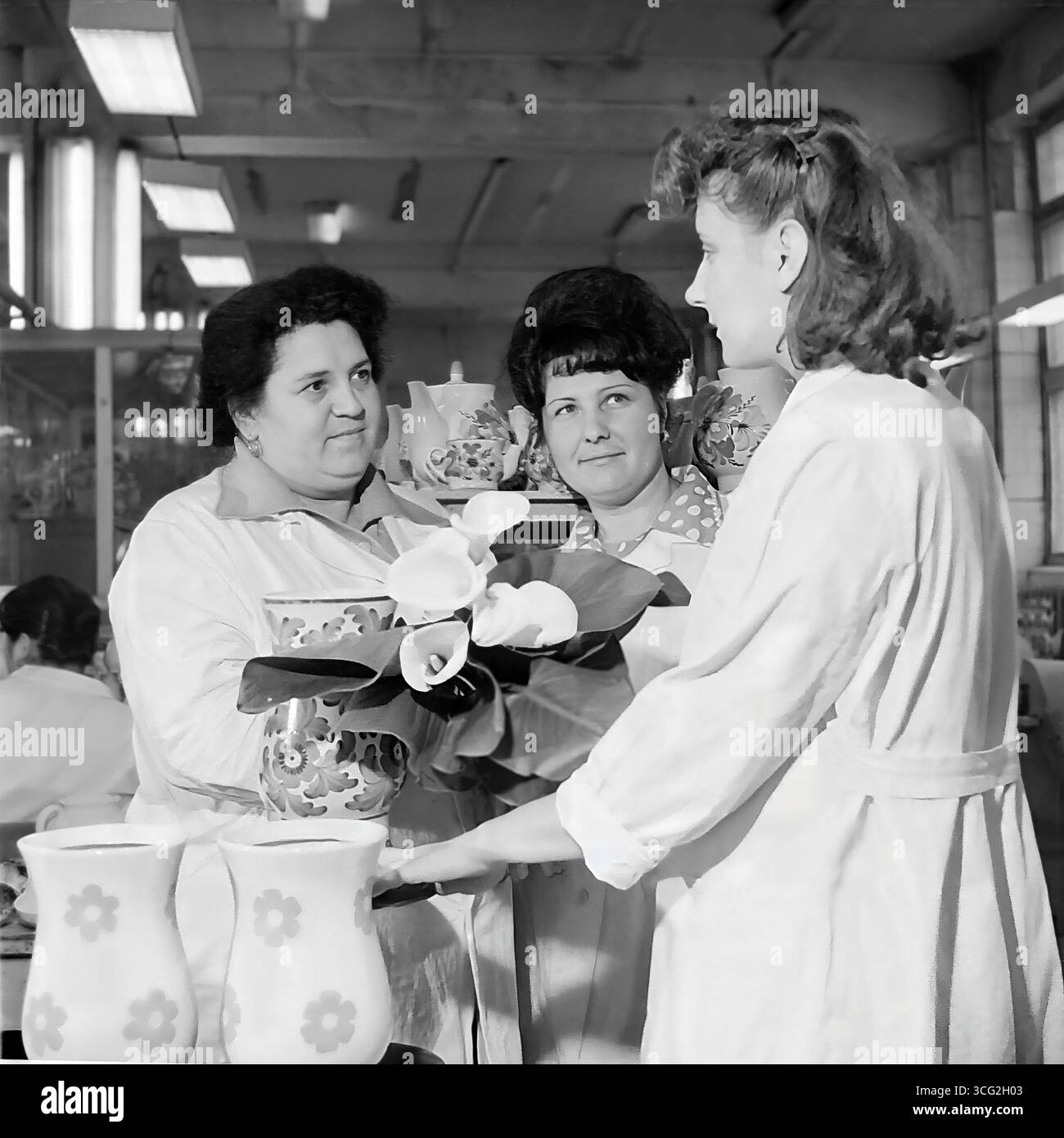 Foto d'archivio delle lavoratrici dello stabilimento ceramico "Keram" di Sloviansk, 1984, sorridenti mentre espongono prodotti finiti, vasi dipinti, in occasione dell'8 marzo (giornata internazionale della donna), simboleggiando il lavoro femminile pacifico nell'industria sovietica Foto Stock