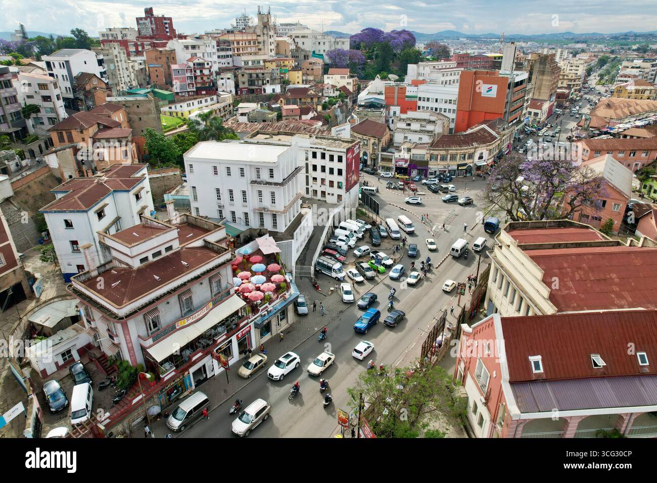Antananarivo (TNR), Madagascar – 2023/11/09: Veduta aerea degli ombrelli sul tetto di Planète Terrasse con le circostanti strade del mercato di Ambohijatovo. Foto Stock