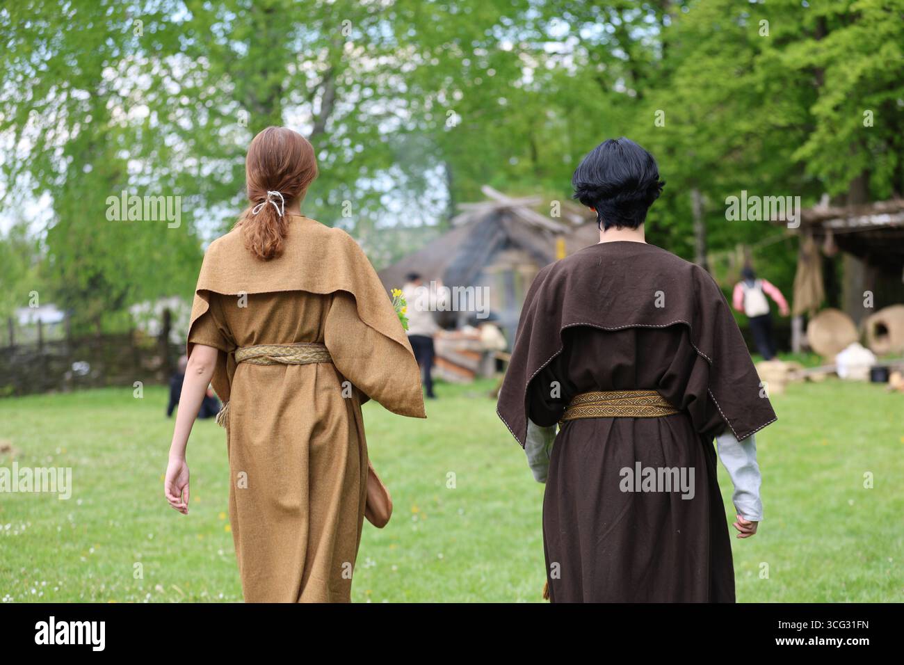 Donne in costumi storici che camminano sull'erba. Foto Stock