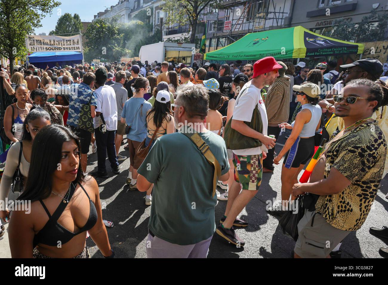 Londra, Regno Unito. 25 agosto 2025. Lungo il percorso si trova una bancarella di bevande rinfrescanti. I partecipanti e i festeggiatori all'annuale People ballano in uno dei tanti sistemi audio lungo il percorso. Il giorno della sfilata principale del Carnevale di Notting Hill il lunedì festivo. Il Carnevale di Notting Hill a Londra è il più grande festival di strada d'Europa e il secondo carnevale di strada più grande del mondo dopo Rio, attirando regolarmente circa 2 milioni di persone durante il fine settimana festivo. Crediti: Imageplotter/Alamy Live News Foto Stock