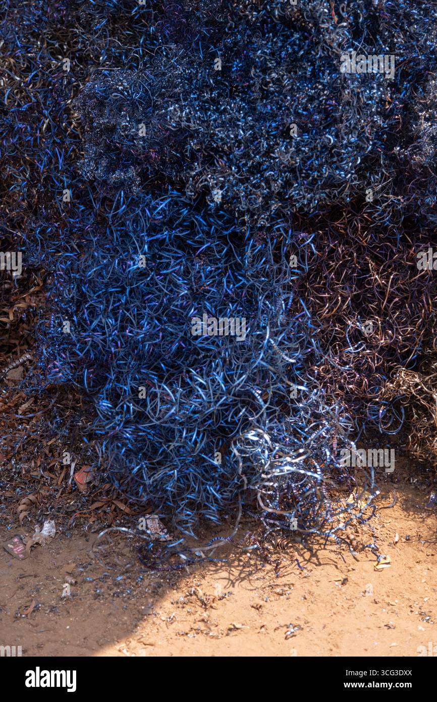 Questa immagine mostra un grande mucchio di reti da pesca marrone e blu, mettendo in evidenza l'attrezzatura marina, la consistenza e il sostentamento costiero Foto Stock