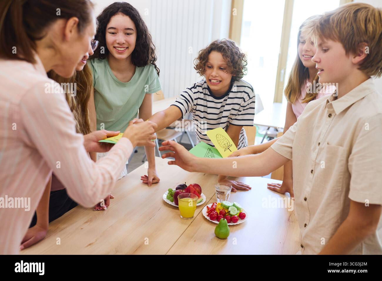 Un allegro gruppo di studenti che si impegnano l'uno con l'altro in una caffetteria, con spuntini salutari e attività di cooperazione, che rappresentano l'amicizia, le Foto Stock