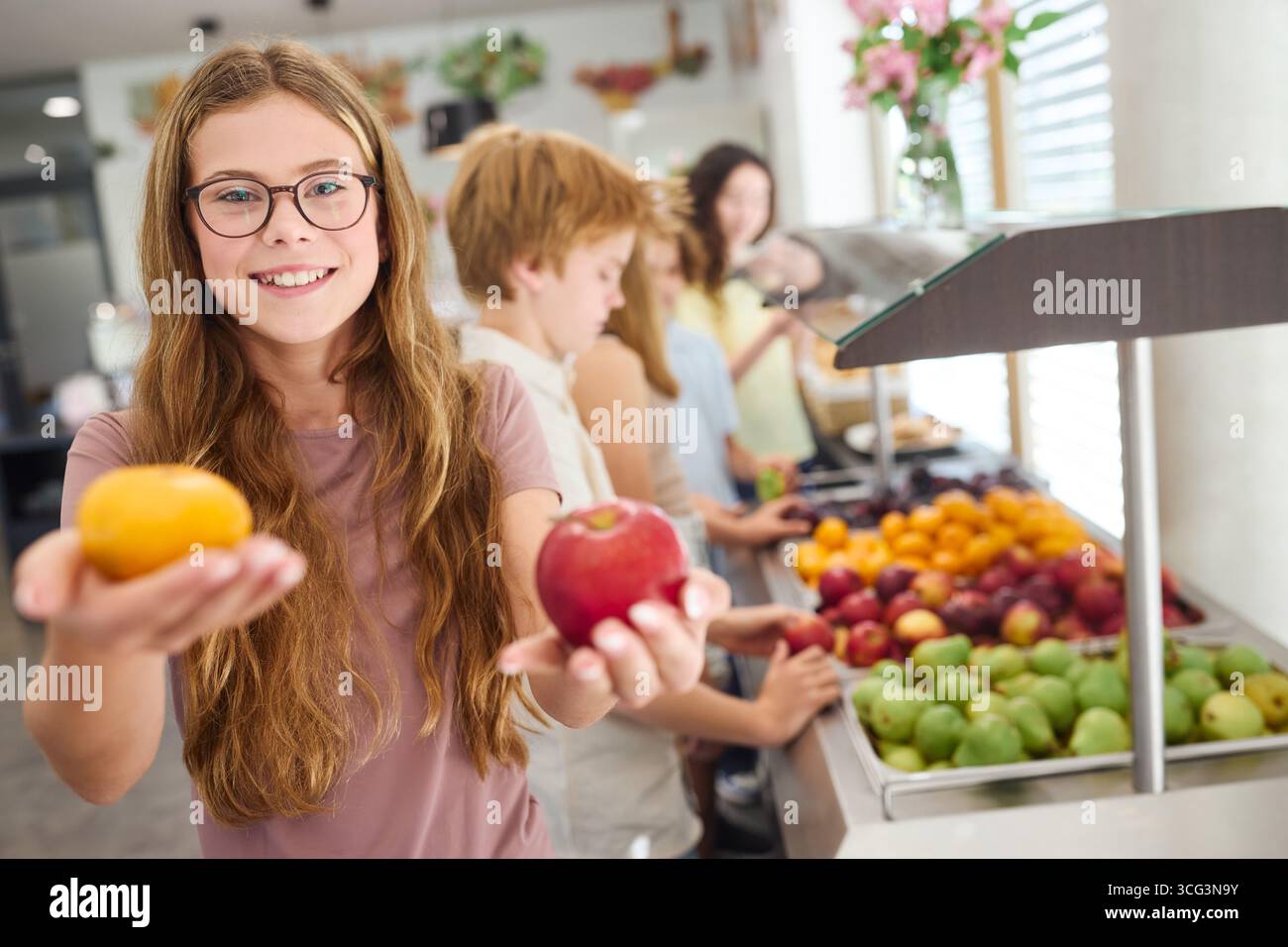 Un gruppo di bambini che sceglie frutta sana da una selezione colorata in una caffetteria scolastica, enfatizzando le opzioni nutrienti e allegre dei pasti Foto Stock