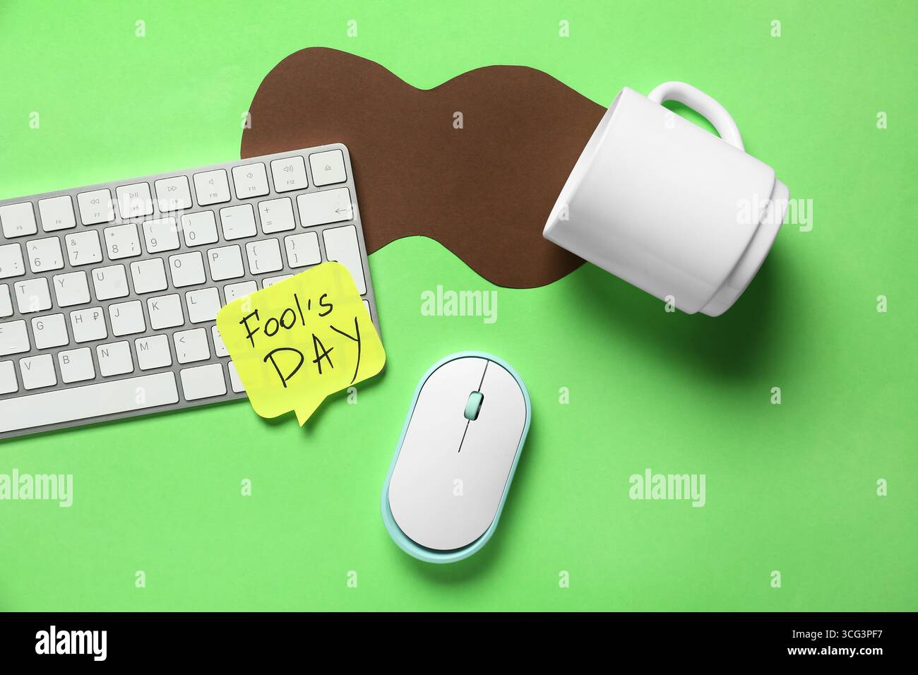 Tastiera del computer, note adesive e scherzo con una tazza di caffè rovesciata su sfondo verde. April Fools Day Pank Foto Stock