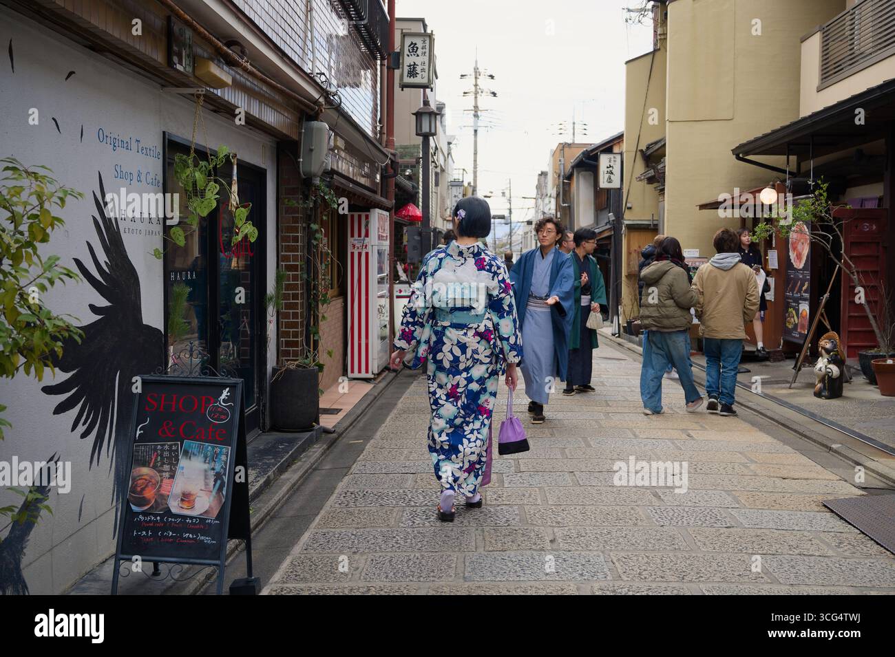Persone in kimono passeggiando attraverso una stretta strada dello shopping a Kyoto Foto Stock