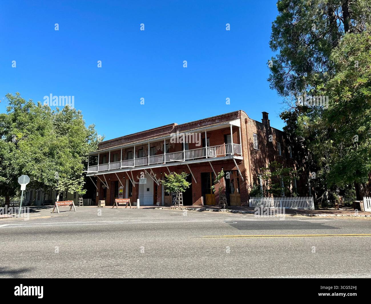 Lo storico Fallon Hotel, un edificio a due piani in mattoni rossi con un prominente balcone in legno, si erge sotto un cielo azzurro limpido in California Foto Stock