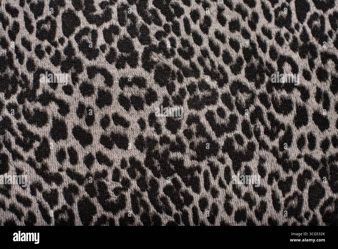 Stampa leopardata ispirata agli animali in tonalità di grigio su un morbido tessuto testurizzato. Adatto per la moda, il design tessile o l'arredamento di interni moderni Foto Stock