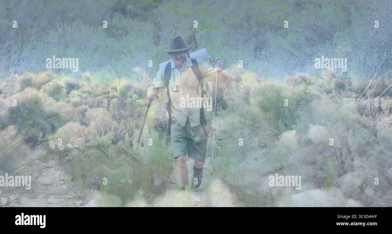 Escursionista che indossa un cappello che stringe un bastone di metallo e personale di legno sul sentiero roccioso con zaino Foto Stock Escursionista che indossa un cappello che stringe un bastone di metallo e personale di legno sul sentiero roccioso con zaino Foto Stock