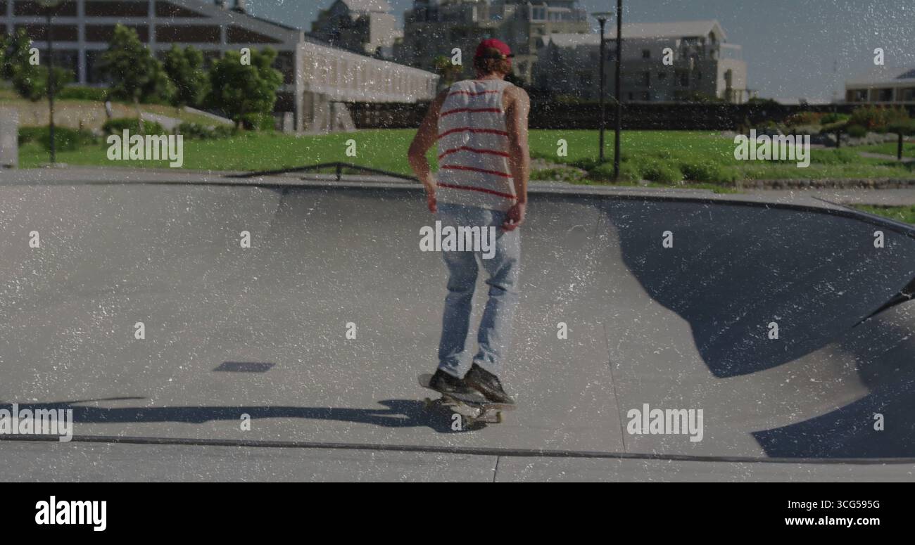 Skateboard con cappello rosso e canotta all'interno di una ciotola di cemento vicino al lampione Foto Stock