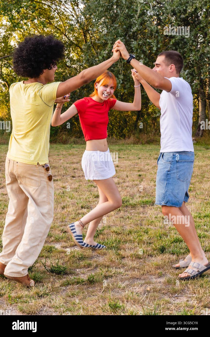 Amici felici che si tengono per mano e si godono una giornata di sole nel parco Foto Stock