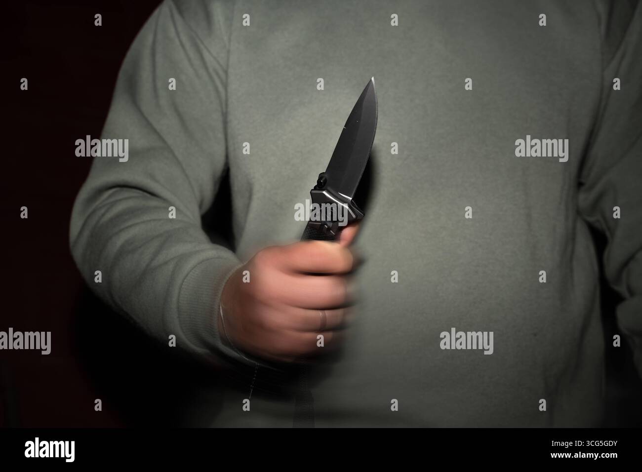 Baviera, Germania - 26 agosto 2025: Uomo con coltello in mano - il movimento del coltello rafforza la minaccia - simbolo di attacchi, criminalità e violenza. Sottolinea l'urgenza della prevenzione e della sicurezza nella vita di tutti i giorni. *** Mann mit Messer in der Hand - Die Bewegung mit dem Messer verstärkt die Bedrohung ein Sinnbild für Angriffe, Kriminalität und Gewalt. Es verdeutlicht die Dringlichkeit von Prävention und Sicherheit im Alltag. Foto Stock