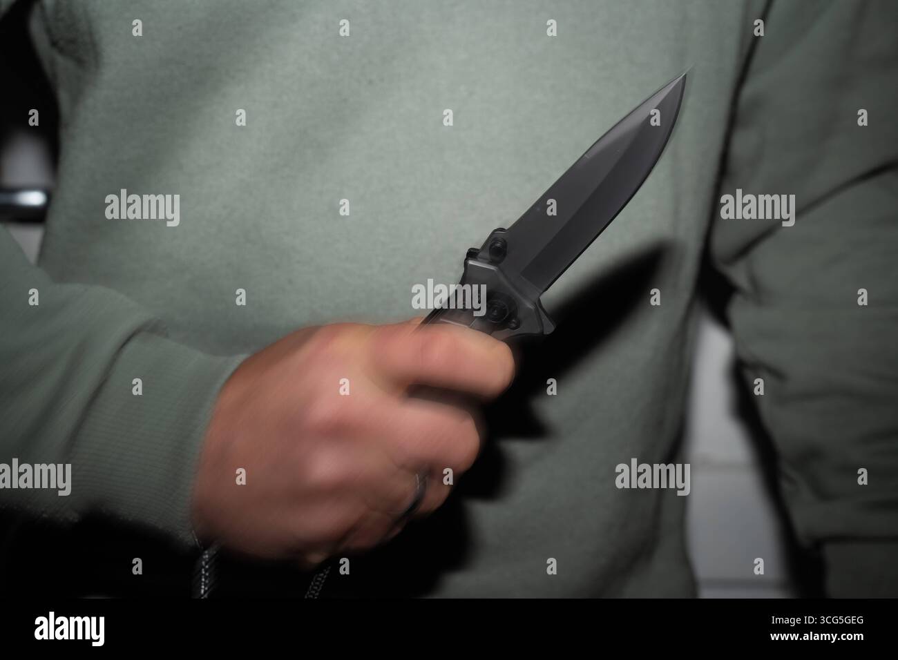 Baviera, Germania - 26 agosto 2025: Uomo con coltello in mano - il movimento del coltello rafforza la minaccia - simbolo di attacchi, criminalità e violenza. Sottolinea l'urgenza della prevenzione e della sicurezza nella vita di tutti i giorni. *** Mann mit Messer in der Hand - Die Bewegung mit dem Messer verstärkt die Bedrohung ein Sinnbild für Angriffe, Kriminalität und Gewalt. Es verdeutlicht die Dringlichkeit von Prävention und Sicherheit im Alltag. Foto Stock