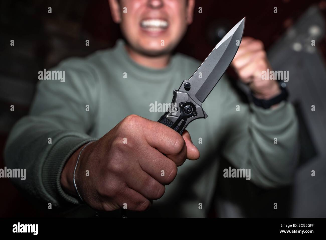 Baviera, Germania - 26 agosto 2025: Uomo con coltello in mano - il movimento del coltello rafforza la minaccia - simbolo di attacchi, criminalità e violenza. Sottolinea l'urgenza della prevenzione e della sicurezza nella vita di tutti i giorni. *** Mann mit Messer in der Hand - Die Bewegung mit dem Messer verstärkt die Bedrohung ein Sinnbild für Angriffe, Kriminalität und Gewalt. Es verdeutlicht die Dringlichkeit von Prävention und Sicherheit im Alltag. Foto Stock