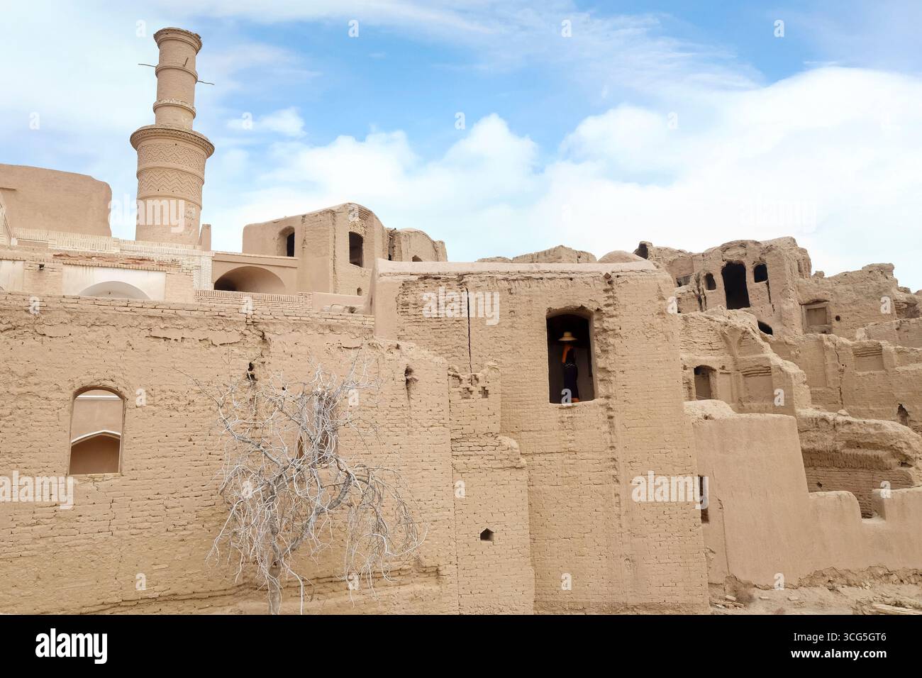 Turista che osserva le antiche rovine di Kharanaq, una storica città fantasma nel deserto nella provincia di Yazd, Iran, una popolare destinazione di viaggio Foto Stock
