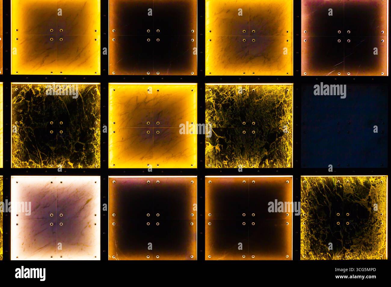 Pareti in piastrelle decorative con illuminazione interna in giallo e bianco con aree scure. Foto Stock