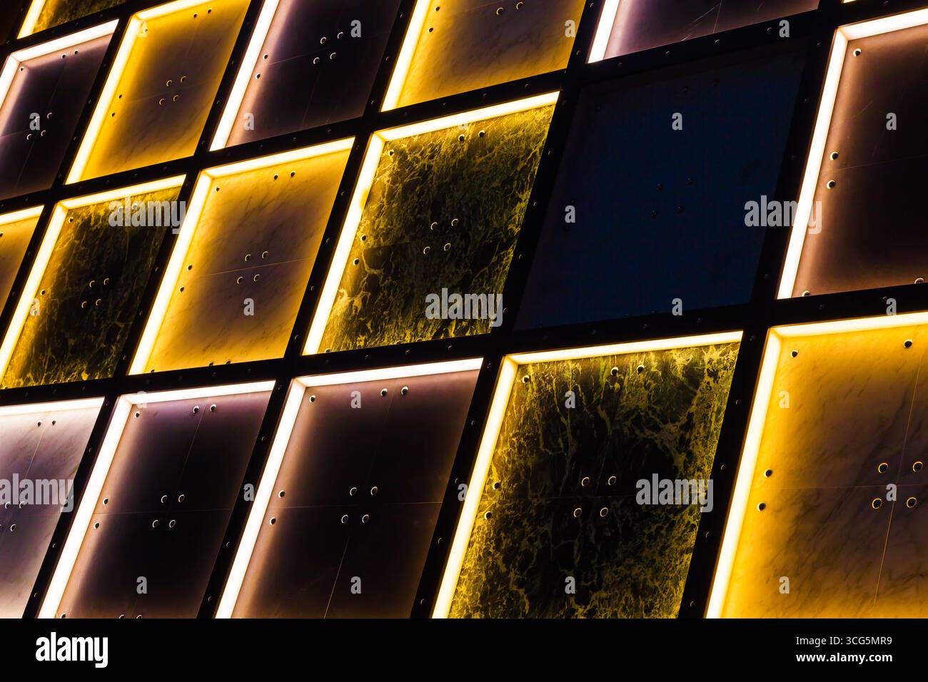 Pareti in piastrelle decorative con illuminazione interna in giallo e bianco con aree scure. Foto Stock