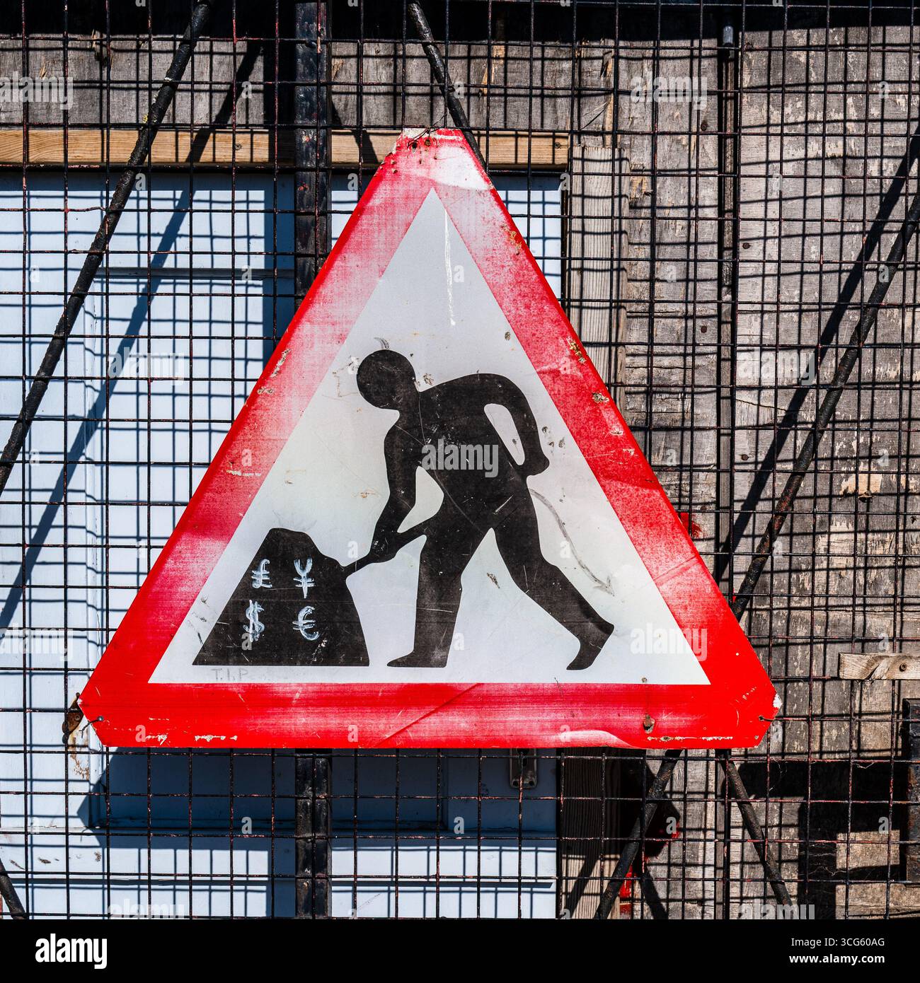Denaro al lavoro: Cartello di costruzione creativo con simboli di valuta globale Foto Stock