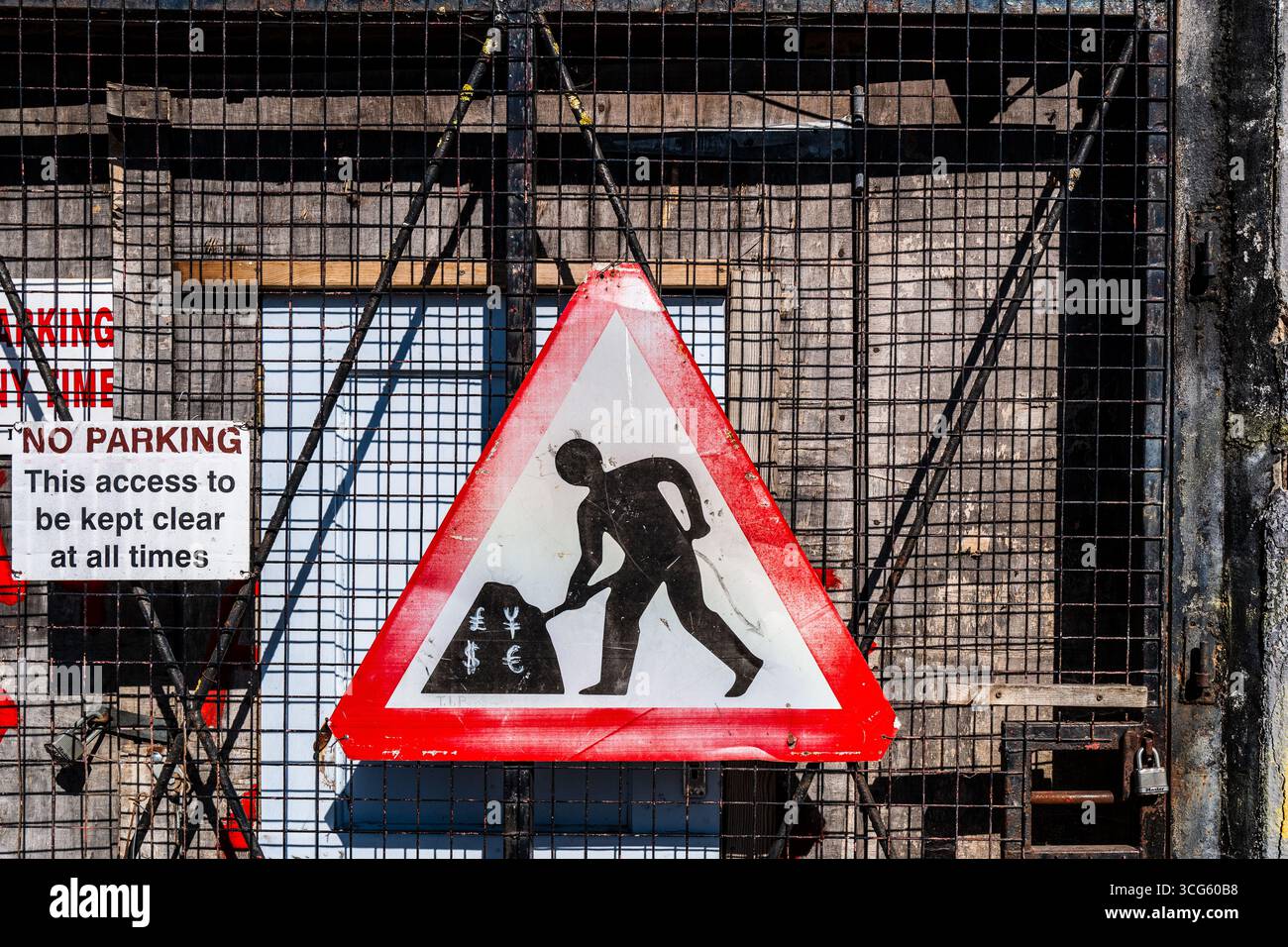 Denaro al lavoro: Cartello di costruzione creativo con simboli di valuta globale Foto Stock