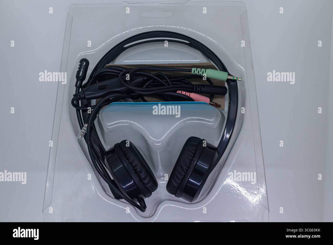 Immagine ravvicinata di cuffie nere con fili isolate su uno sfondo bianco pulito. Perfetto per la presentazione di apparecchiature audio, elettronica e accessori musicali. Foto Stock