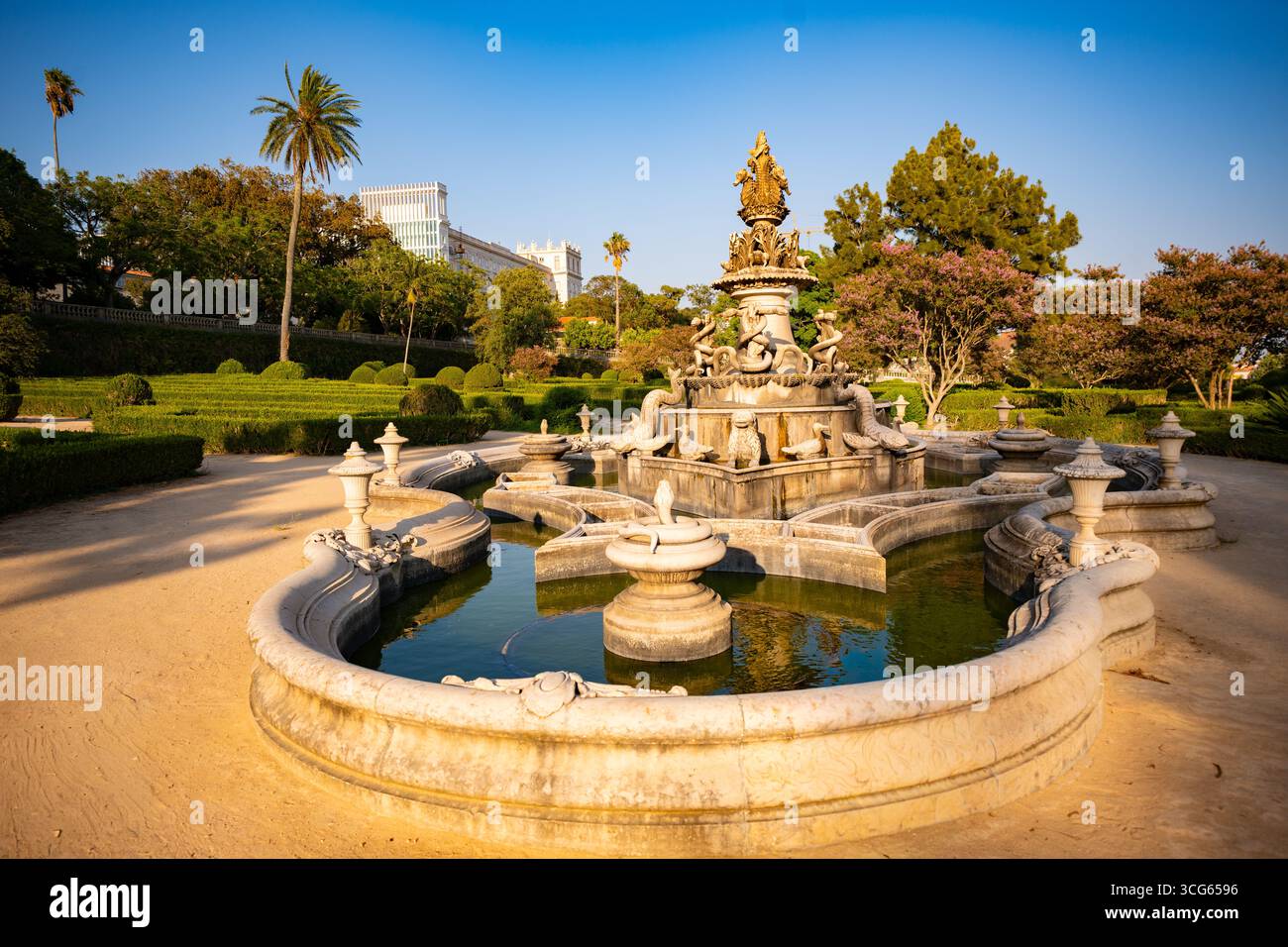 Fontana di Jardim Botânico da Ajuda a Lisbona, il più antico giardino botanico del Portogallo, alla luce della sera. Palacio Nationl da Ajuda sullo sfondo. Foto Stock