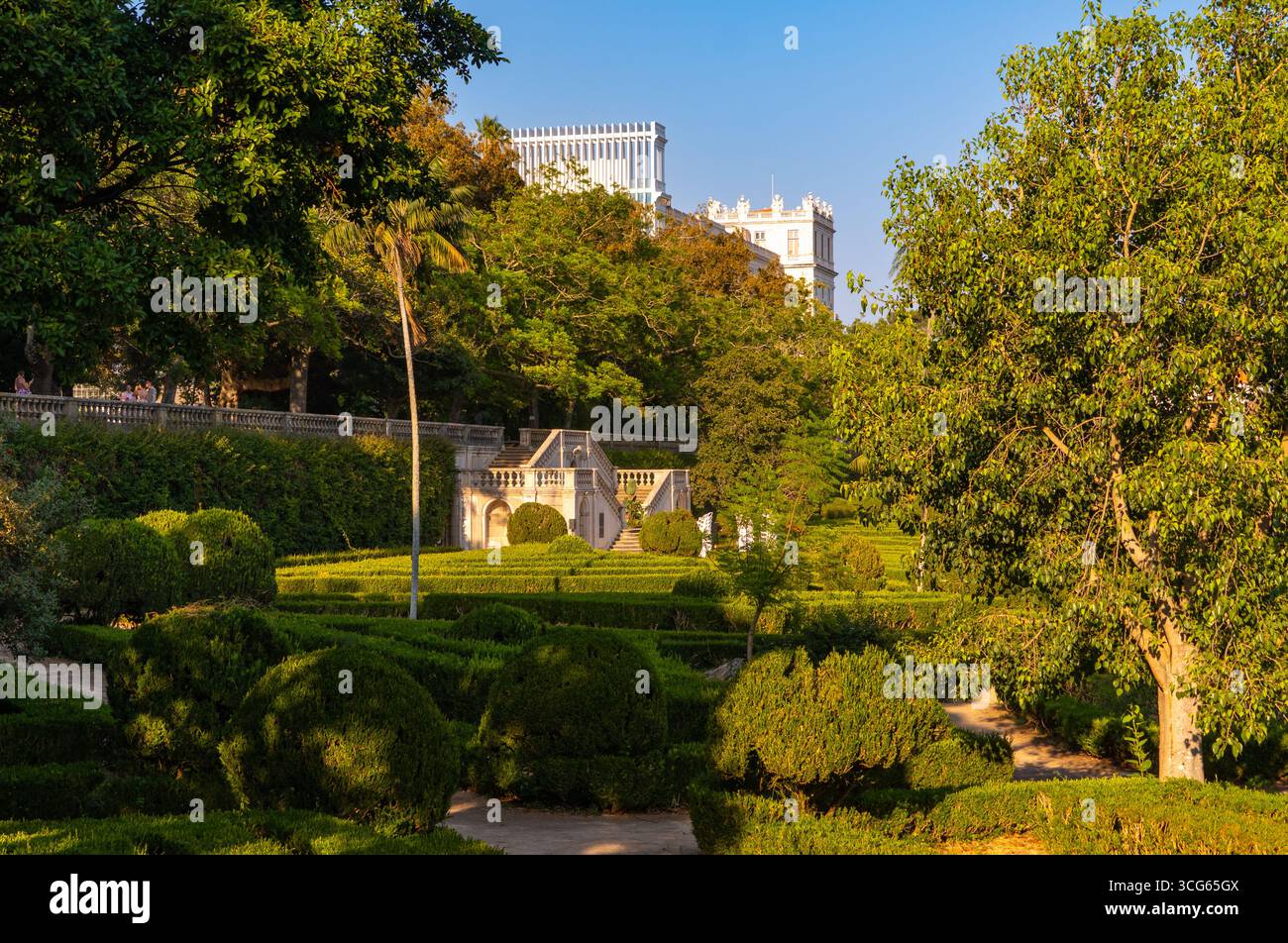 Elegante scalinata in pietra e siepi curate al Jardim Botânico da Ajuda di Lisbona, il più antico giardino botanico del Portogallo, inondato dalla luce serale. Foto Stock