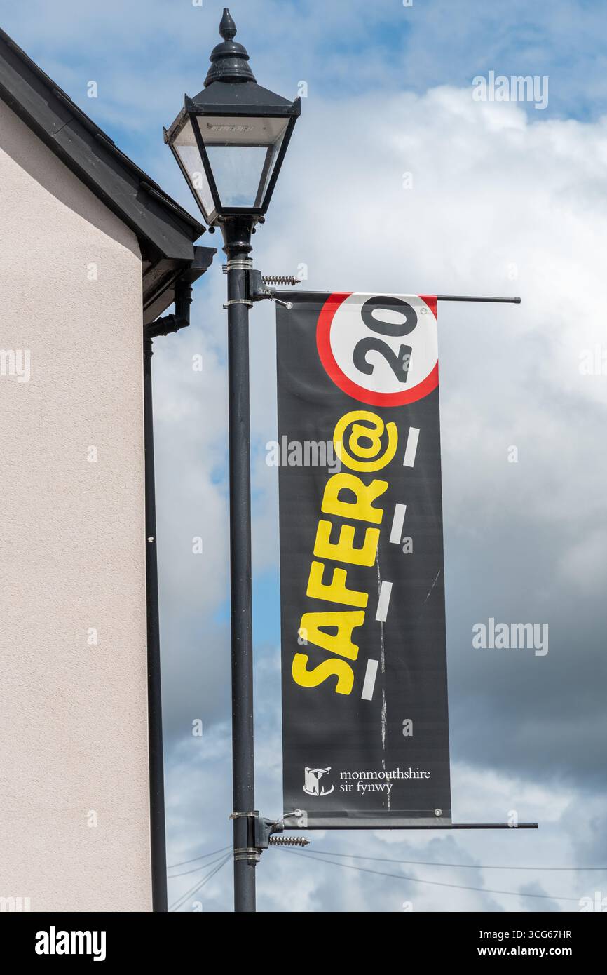 Messaggio Safer @ 20 su banner su lampione in Galles, Regno Unito. Più sicuro a 20 km/h, segnale del limite di velocità Foto Stock