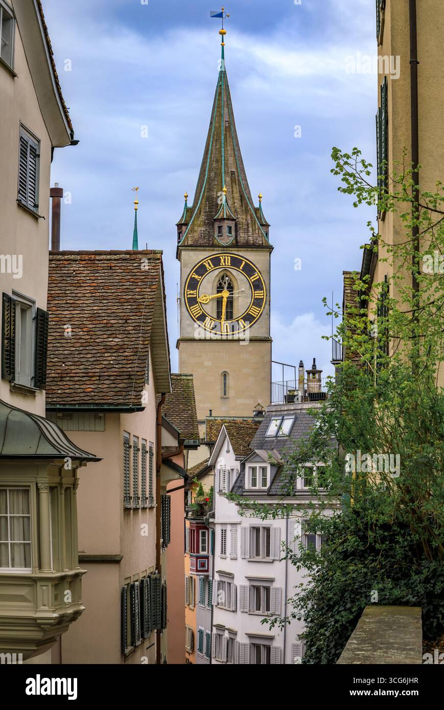 L'iconica torre dell'orologio della Chiesa di San Pietro incorniciata da edifici storici circostanti nella città vecchia o nell'Altstadt di Zurigo, Svizzera Foto Stock