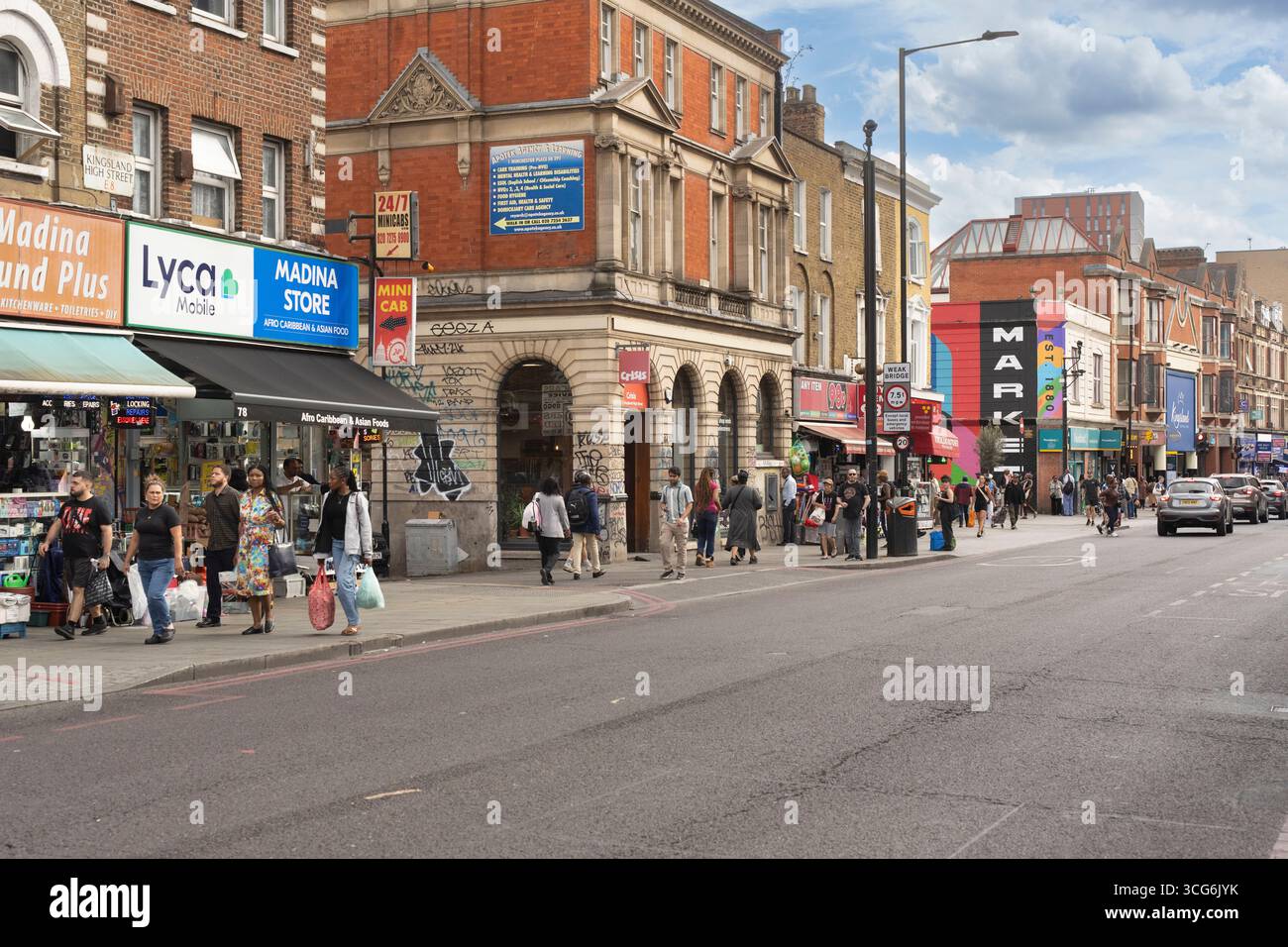 Gli amanti dello shopping passeggiano lungo Kingsland High Street a Dalston, Londra. La strada è costeggiata da negozi e ristoranti, che riflettono la vivace comunit della zona Foto Stock