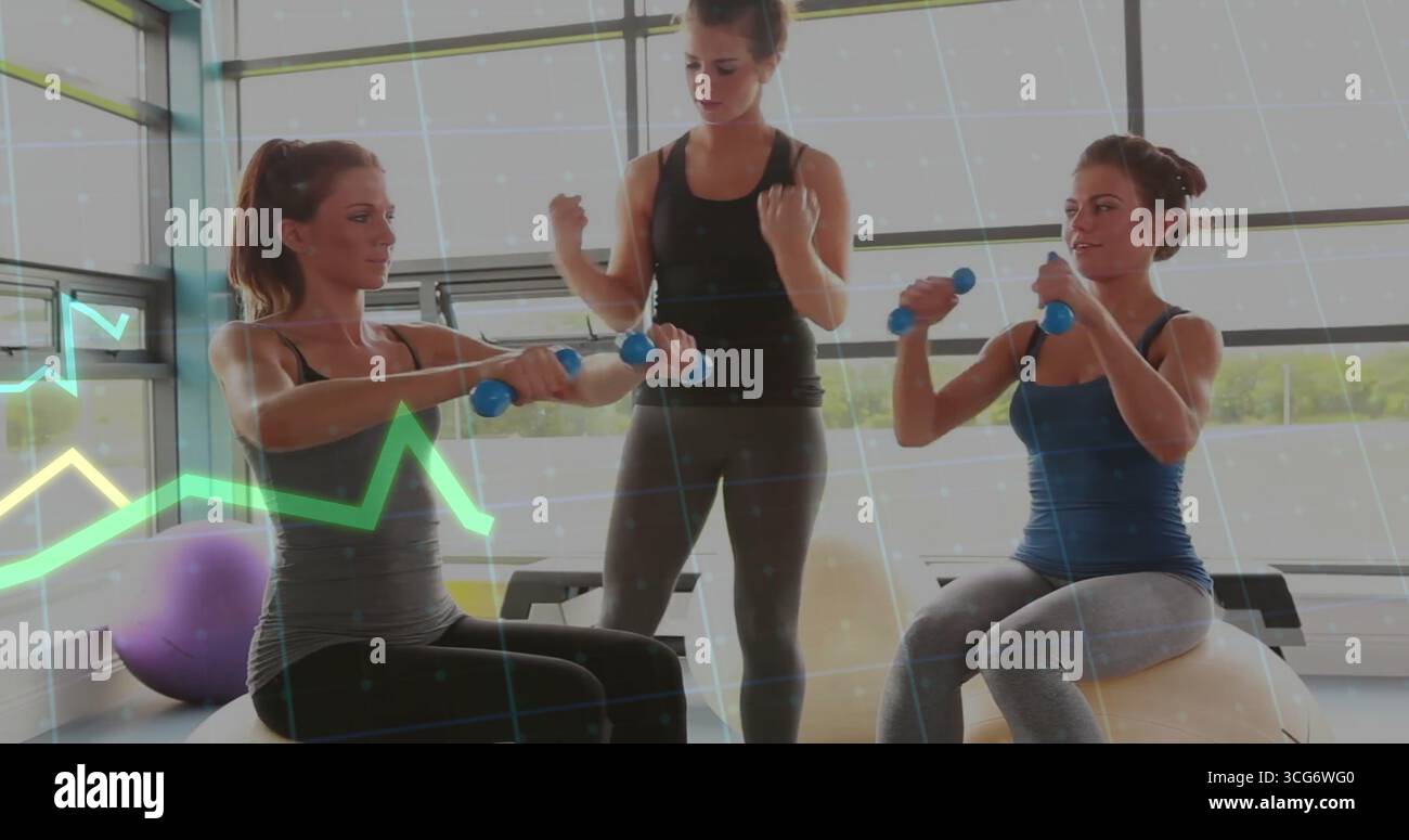 Guidare due donne che indossano abbigliamento sportivo sollevando manubri su palle da ginnastica in palestra, con palla viola Foto Stock