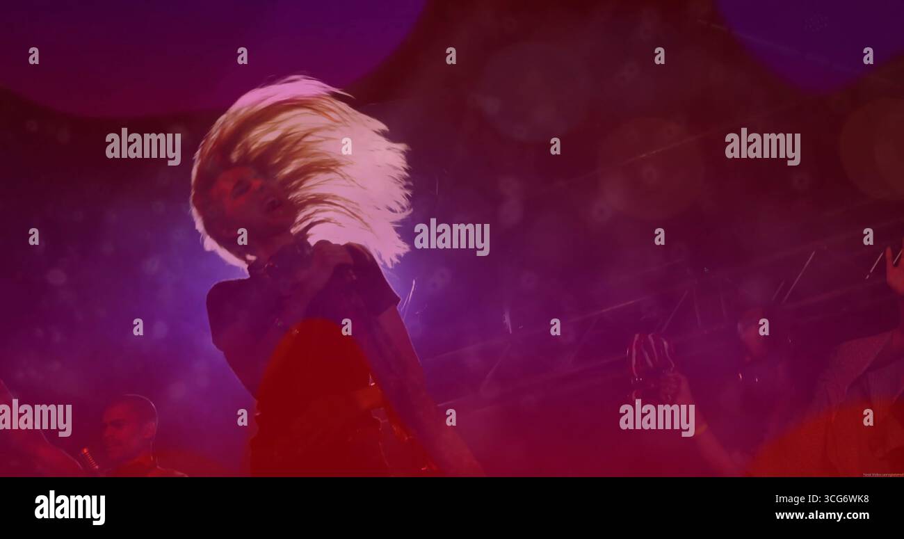 Ribalta la performer femminile rilanciando lunghi capelli biondi sul palco della musica dal vivo, con nebbia e smartphone Foto Stock