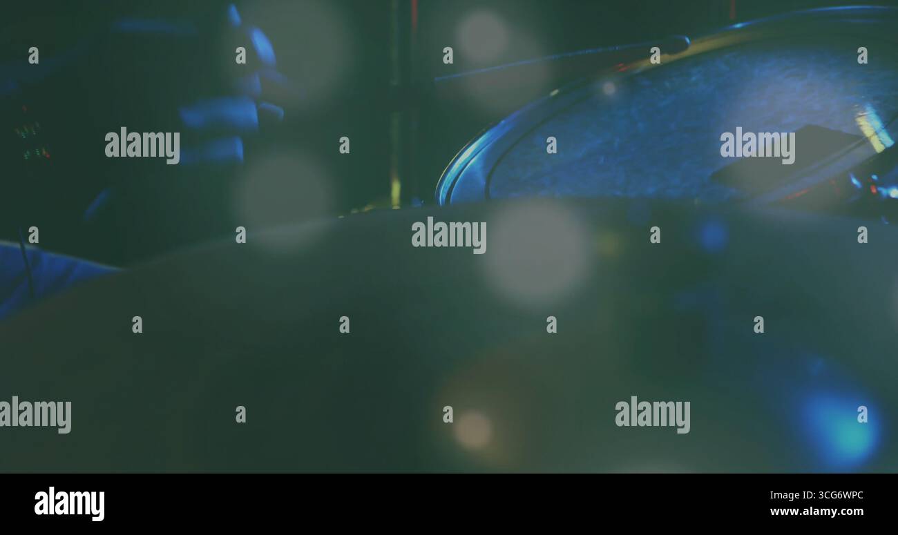 Evidenziando la testa del tamburo con la bacchetta, lo smartphone e il bordo metallico sotto la luce del palcoscenico, spazio di copia Foto Stock