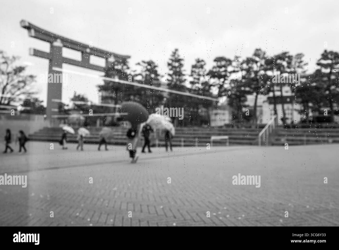 Immagine monocromatica di persone che camminano vicino a una porta torii e agli alberi, viste attraverso le gocce di pioggia su vetro, Okazaki Seishojicho, Sakyo Ward, Kyoto, Kansai, Ciao Foto Stock