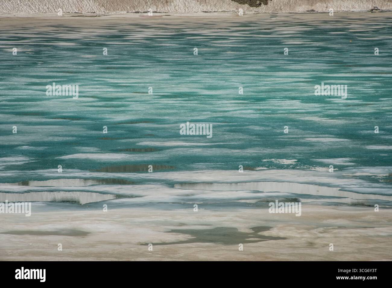 Particolare delle acque di scongelamento di Lac de l'Eychauda, Vallouise-Pelvoux, Francia. Il lago Eychauda è un lago naturale di origine glaciale, formato dal ritiro del ghiacciaio Séguret Foran, alimentato dal Torrent des Oules, acqua di fusione dal ghiacciaio. Si scongela solo per pochi mesi durante un periodo estivo molto breve. Il lago può essere raggiunto attraverso un'escursione attraverso la magnifica valle di Eychauda, ai margini del Parco Nazionale di Écrins, Hautes-Alpes, Francia. Foto Stock