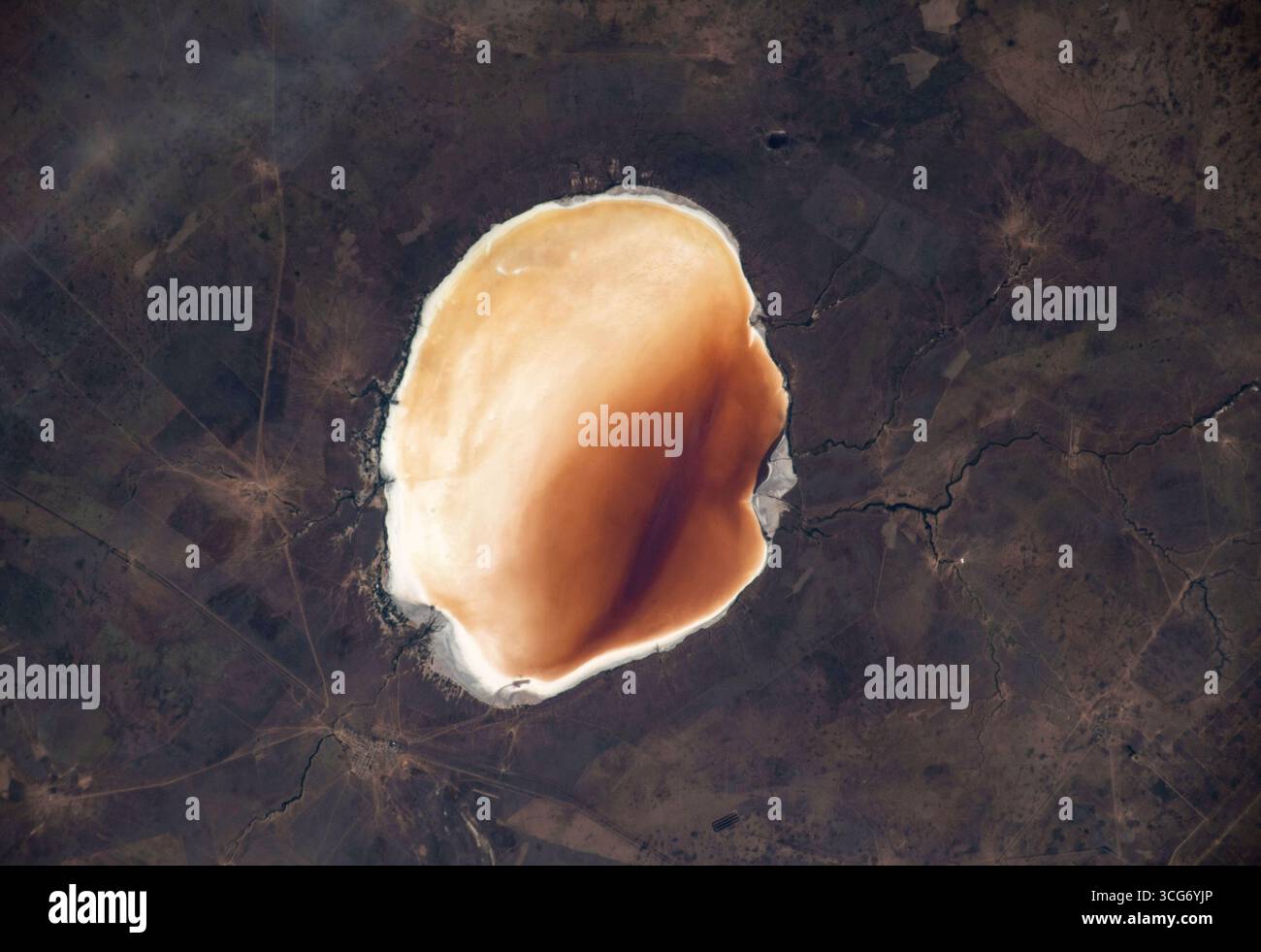Il lago Elton, visto da 258 miglia sopra la Terra, si trova nel sud-ovest della Russia vicino al Kazakistan. È il più grande lago minerale d'Europa e uno dei laghi naturali più salati del mondo. Con una superficie di 152 km quadrati, le sue acque poco profonde e ricche di minerali sono state utilizzate per scopi terapeutici per secoli. Il lago si trova nella depressione del Caspio, sotto il livello del mare, e la sua superficie luminosa e i bordi minerali bianchi lo rendono facilmente visibile dallo spazio. Una versione ottimizzata di un'immagine originale della NASA: Credit: NASA Foto Stock
