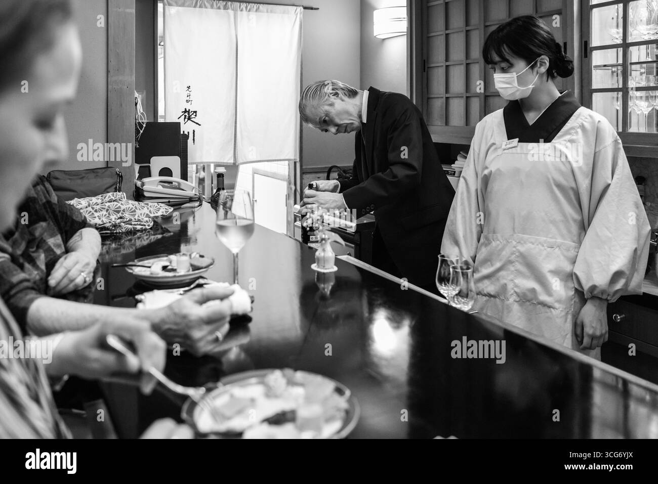 Un momento sincero al Pontocho Misoguigawa, ristorante francese con personale e clienti che godono di un'esperienza culinaria tradizionale, enfatizzando l'hospita Foto Stock